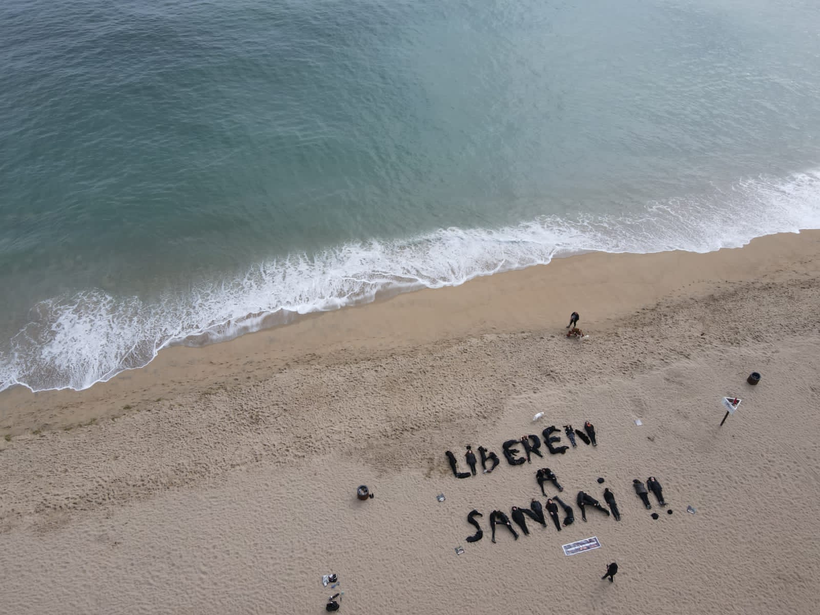 Activistas en la playa formando "liberen a Sandai" con sus cuerpos.
